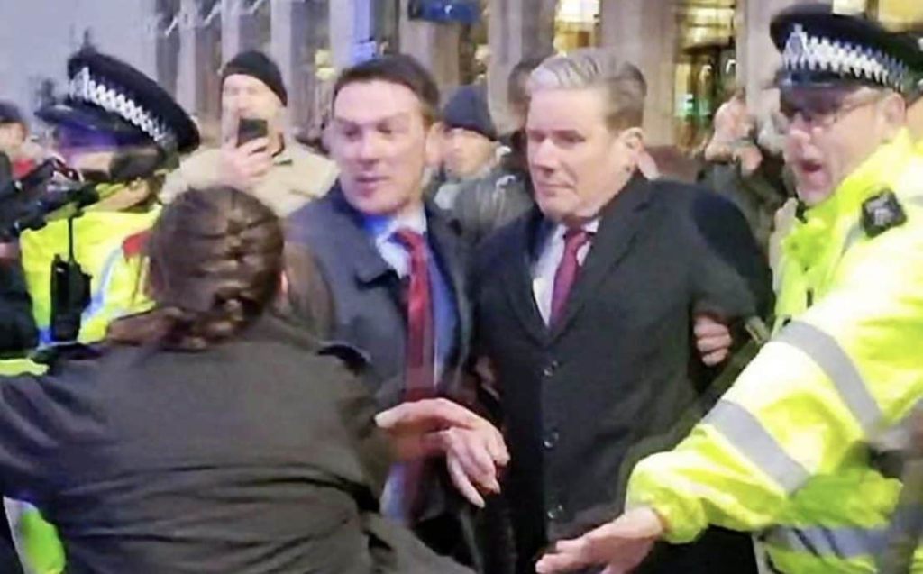 Keir Starmer being escorted by Police through a crowd of protestors 